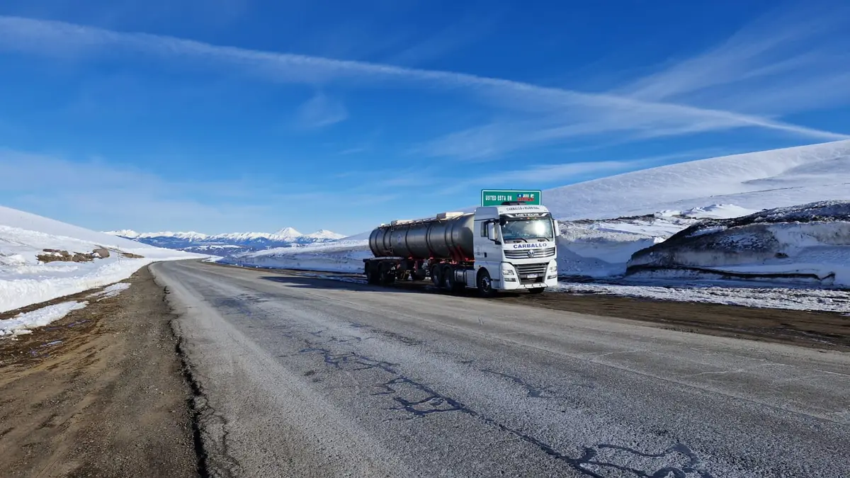 Camión cisterna en una ruta de cordillera con nieve